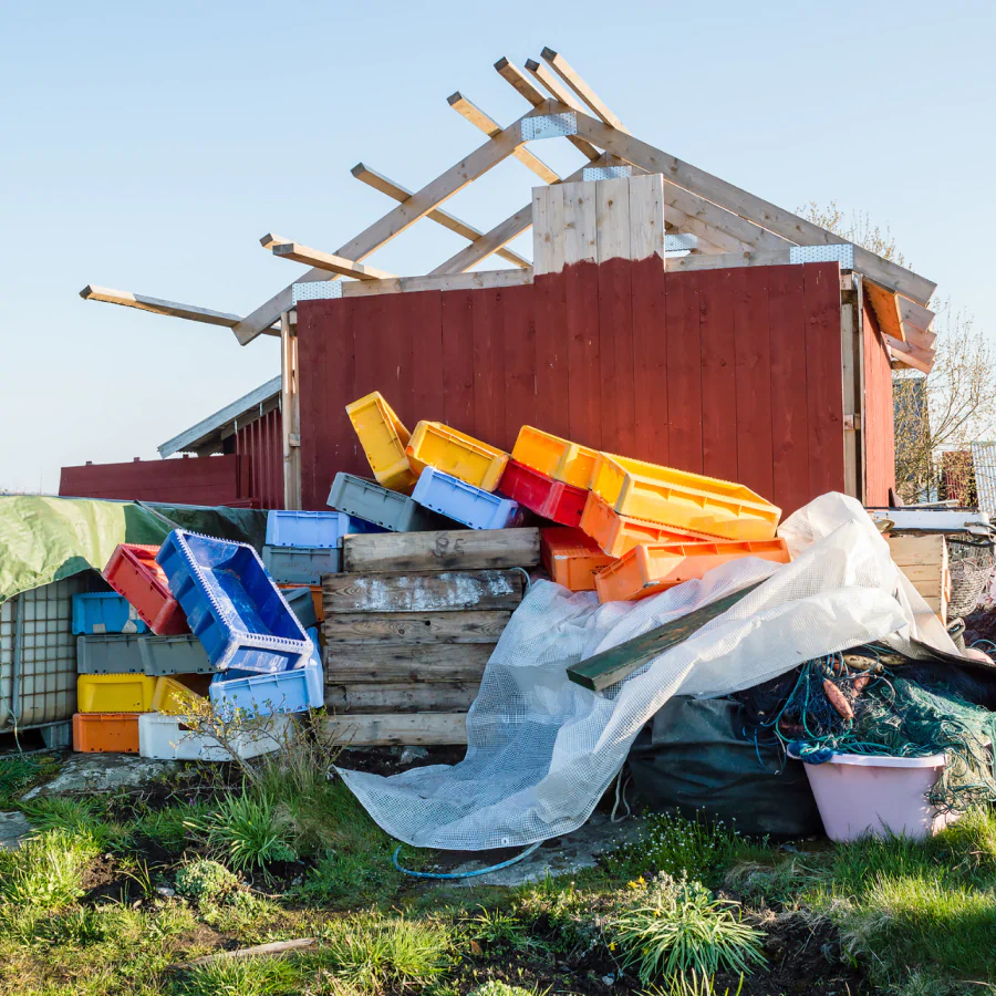 a pile of junk near a damaged shed